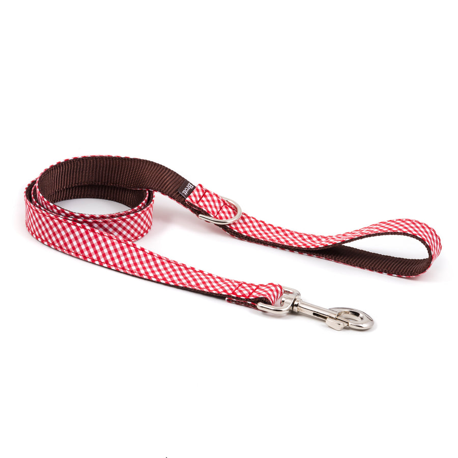 Detalle de la correa para perro Maians de Brott mostrando el tejido Vichy rojo y la base de nailon marrón