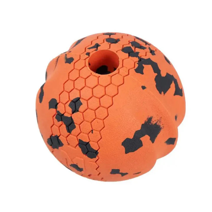 Pelota ultrarresistente Dog Ball de Non-stop Dogwear en color naranja y negro con textura hexagonal y centro hueco para juegos de lanzar y buscar.