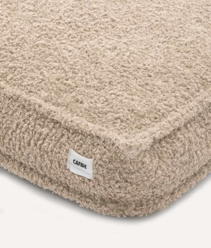 Detalle de esquina de cama cuadra de la marca cafide de borreguito beige
